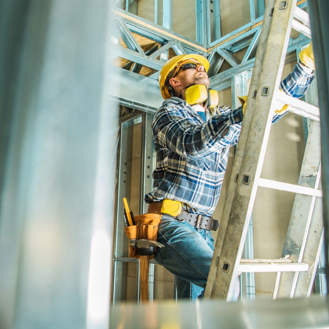 A construction employee climbing a ladder