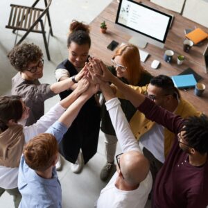 a team of employees putting their hands in the middle